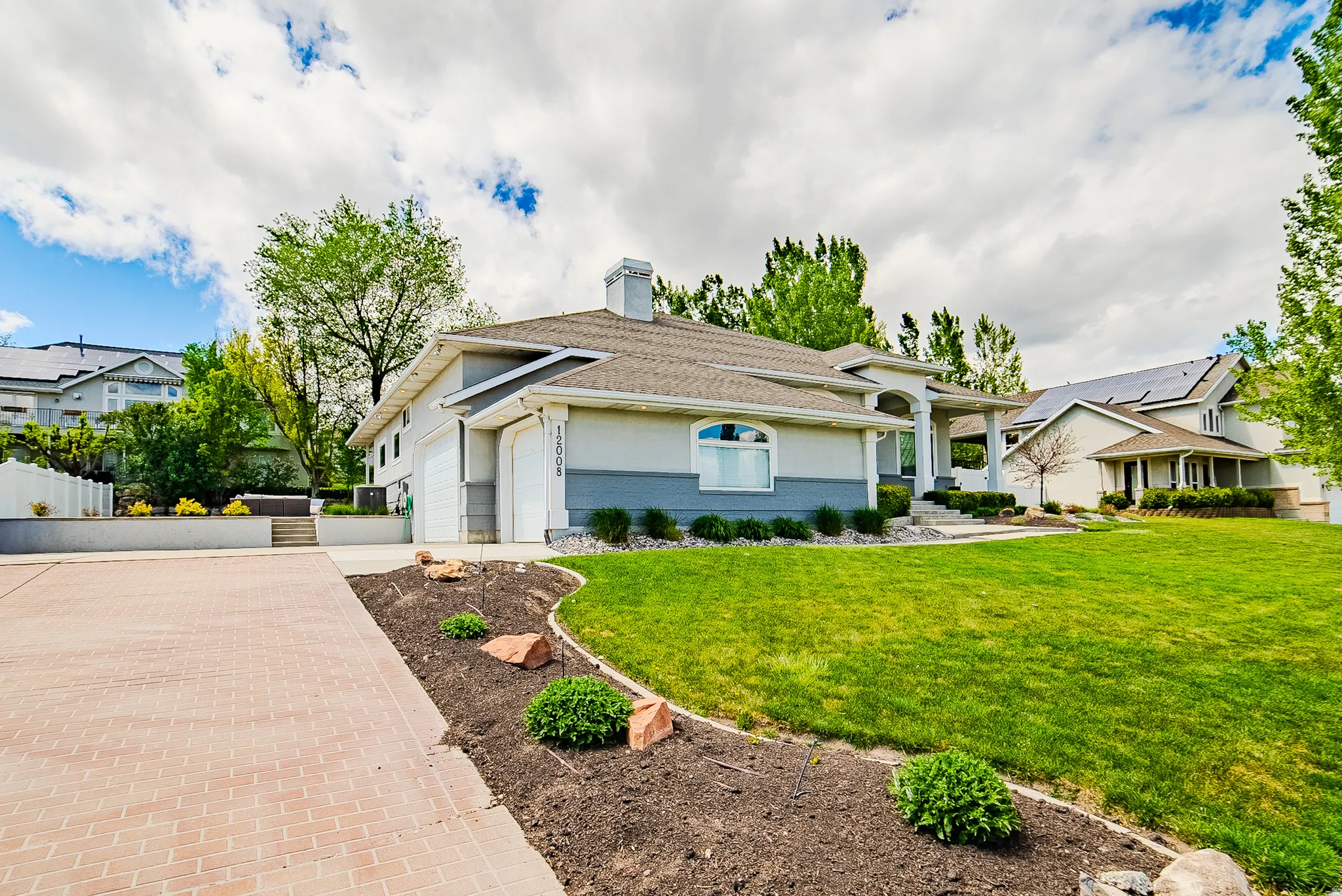 View of front of home featuring concrete driveway, a garage, a front lawn, a chimney, and brick siding