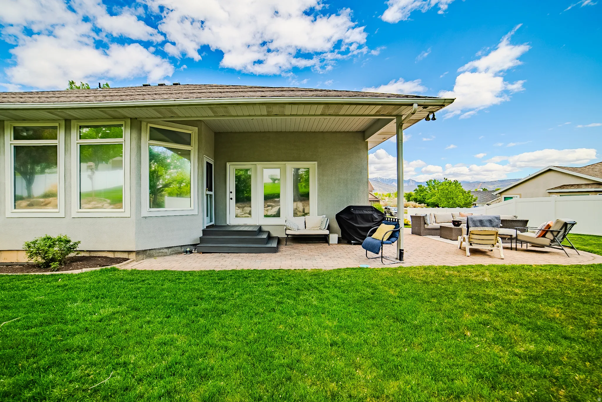 Rear view of house featuring an outdoor lounge area, a patio, a mountain view, stucco siding, and entry steps