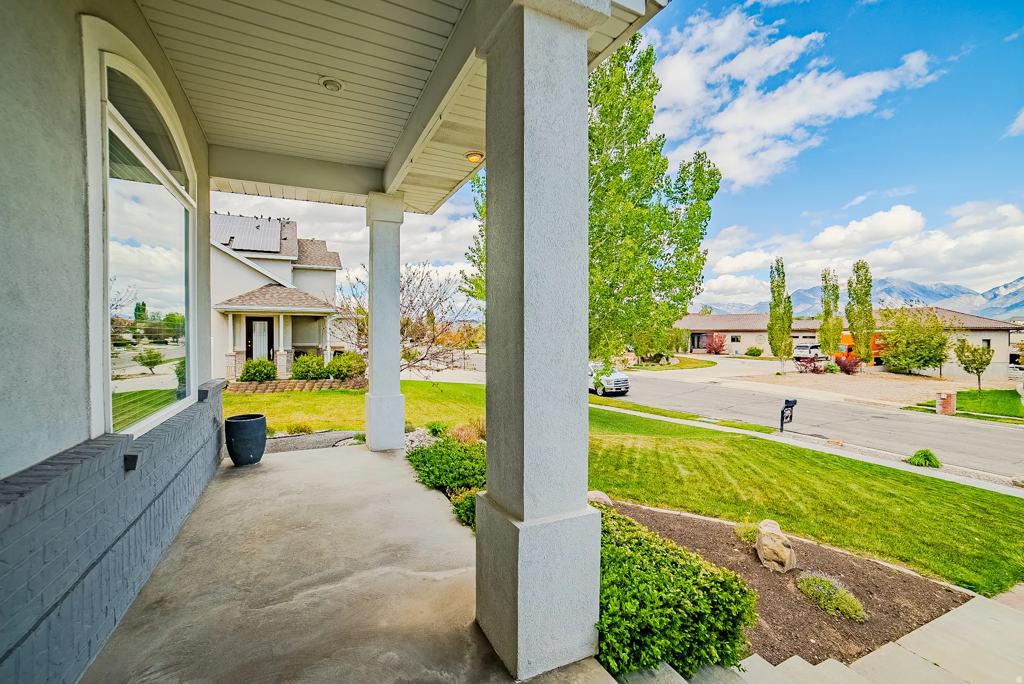 Porch with a mountain view, a yard, and a residential view