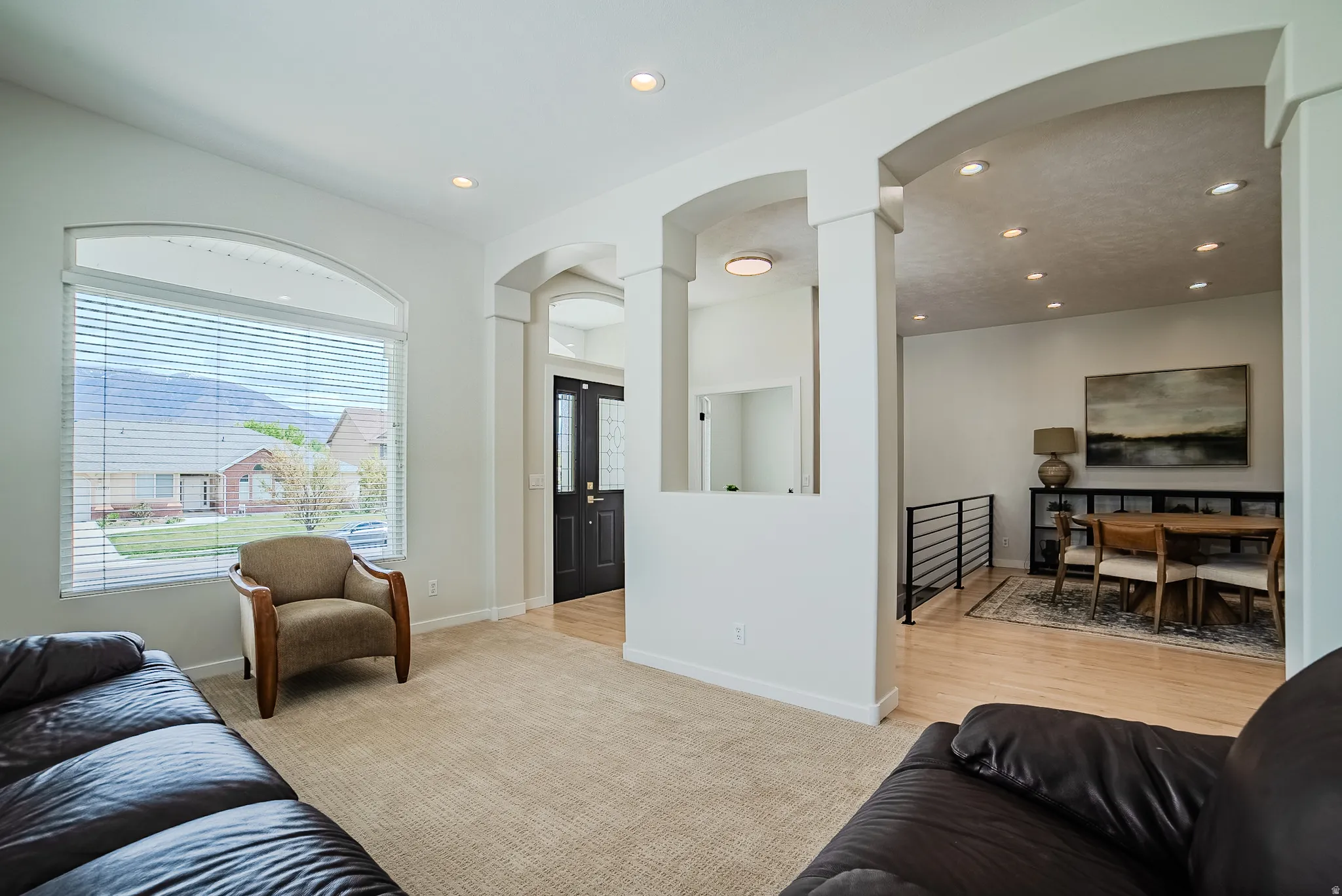 Living room featuring arched walkways, light carpet, recessed lighting, and decorative columns