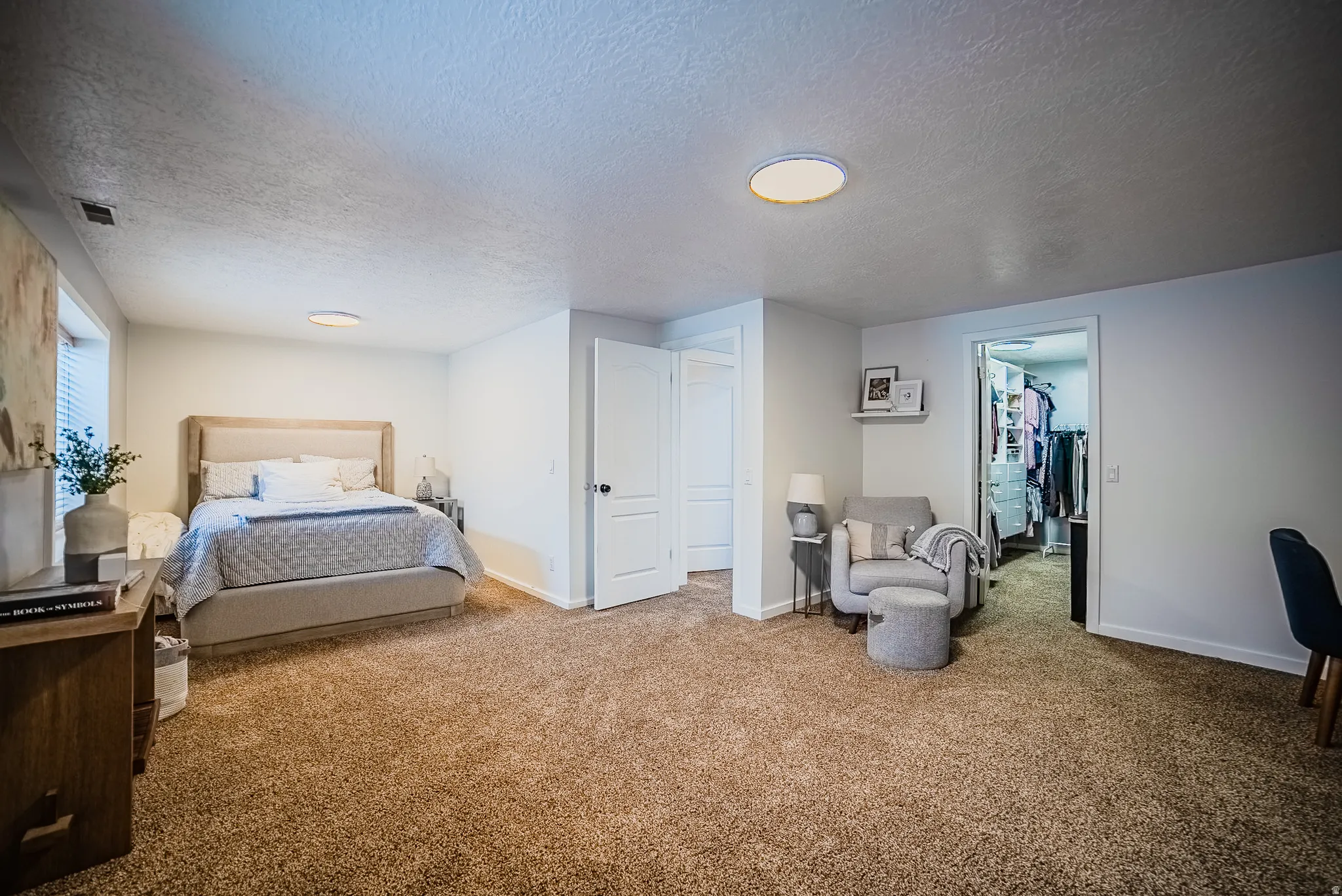 Carpeted bedroom featuring a walk in closet and a textured ceiling