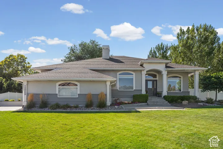 Stucco exterior with stone accents, covered entry, arched windows, and an attached garage