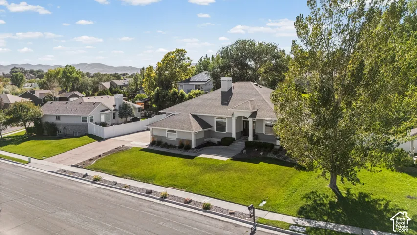 Single-story residence with a gray exterior, stone facade accents, and a dark shingle roof