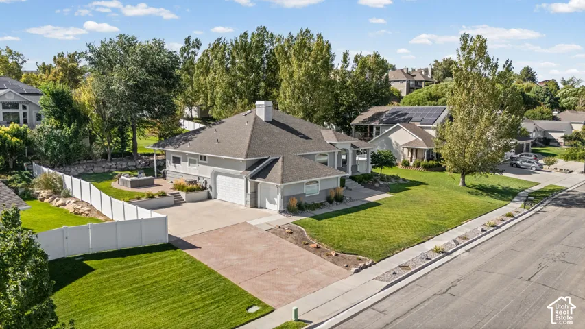 Expansive brick paver driveway with a two-car garage