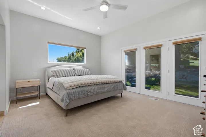 Recessed lighting, ceiling fan, expansive windows, multiple French doors, and neutral carpeting