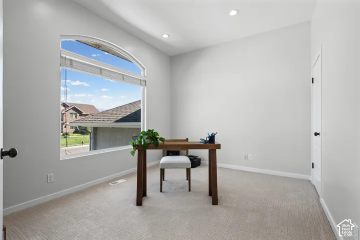 Arched window with blinds, recessed ceiling lighting, and light-toned wall paint