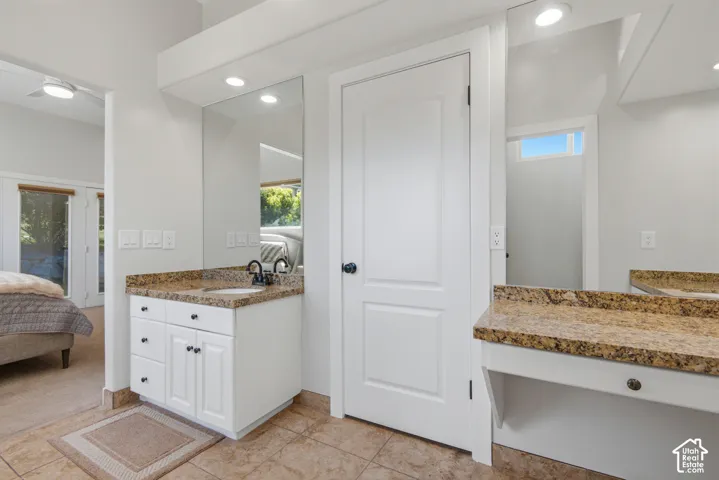 Dual vanity area featuring white cabinetry with dark hardware, granite countertops, and individual mirrors