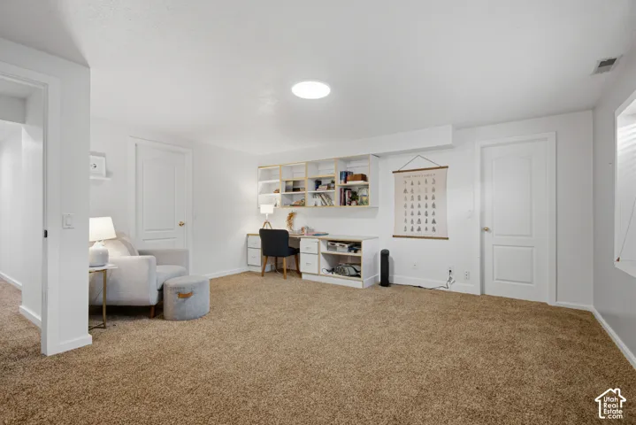 Built-in desk with shelving, recessed lighting, and soft carpet flooring