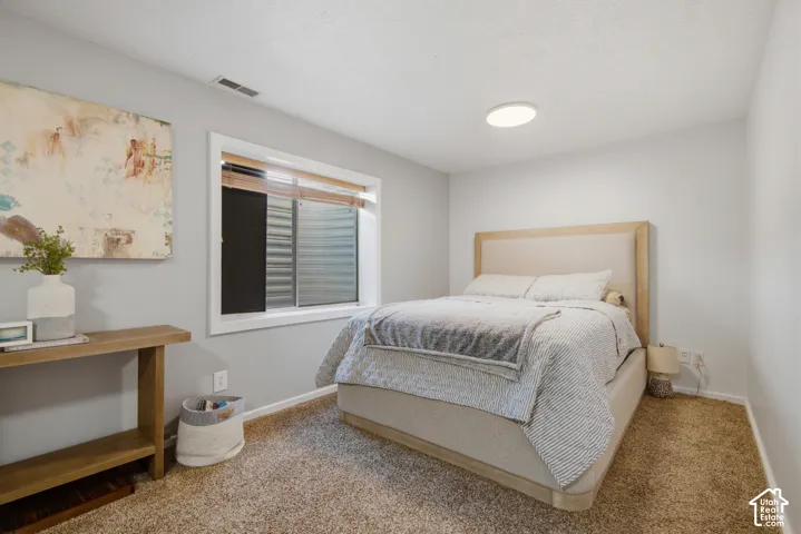 Wall-to-wall carpeting and white walls with a window featuring horizontal blinds