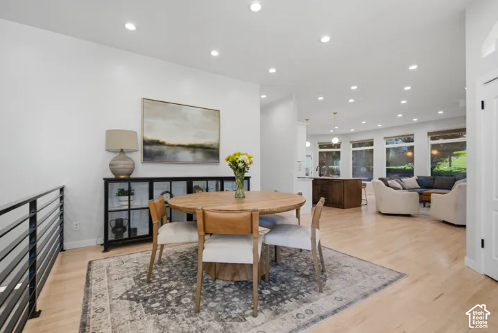 Recessed lighting, light wood-finish flooring, and a modern horizontal railing