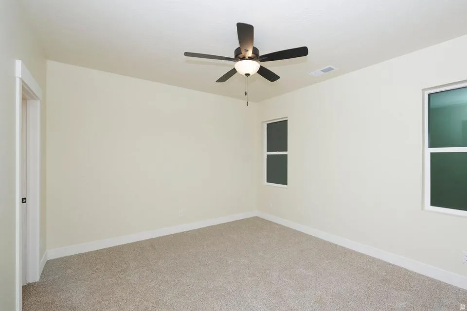 Unfurnished bedroom with carpet floors and ceiling fan