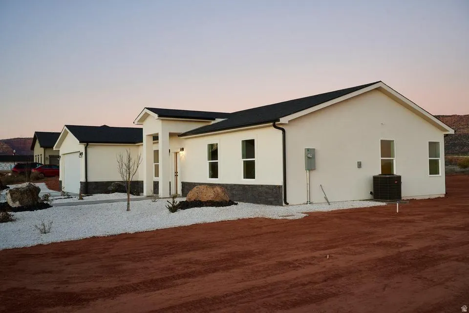 View of property exterior with stucco siding and stone siding