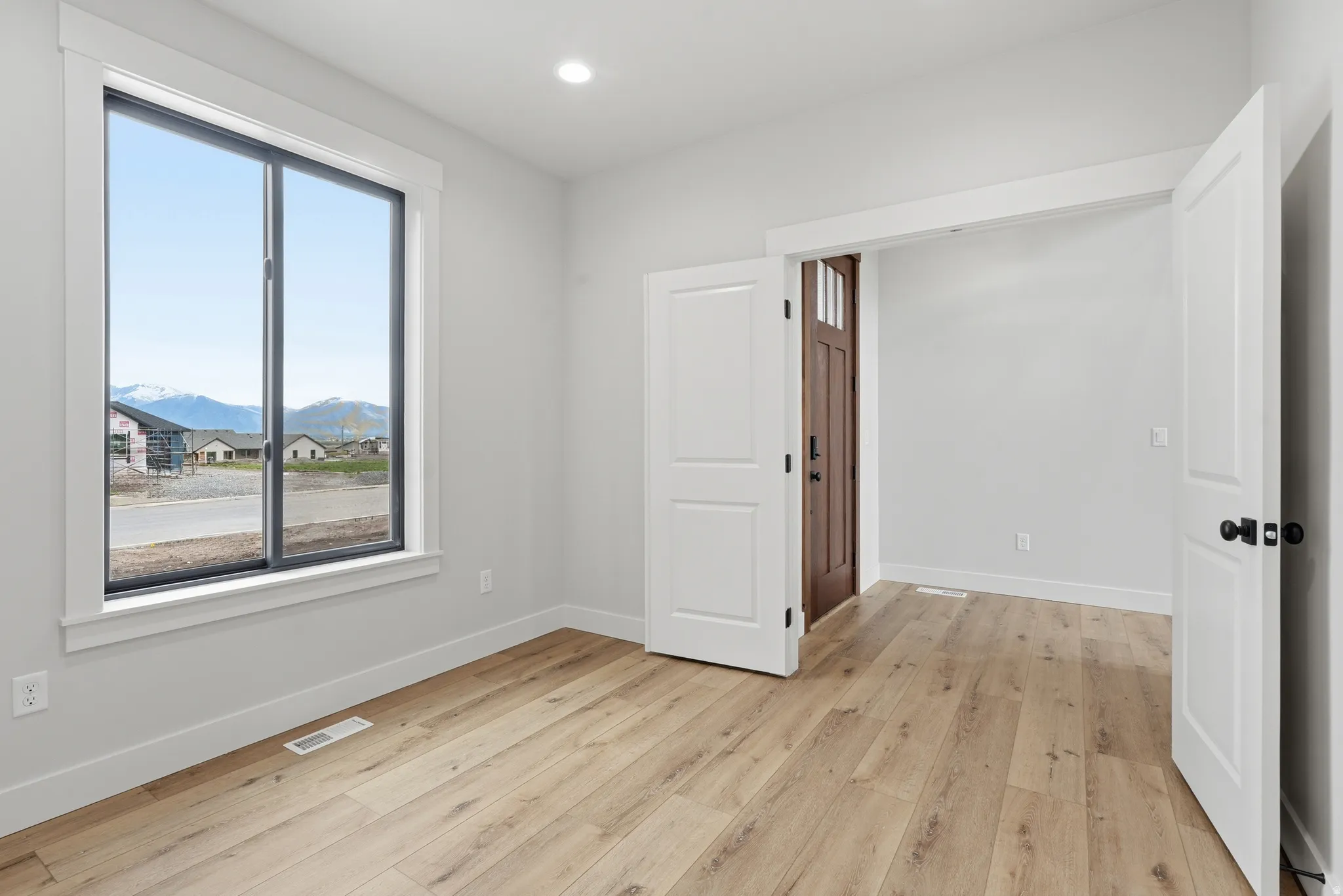 Spare room featuring light wood-type flooring, a mountain view, and recessed lighting
