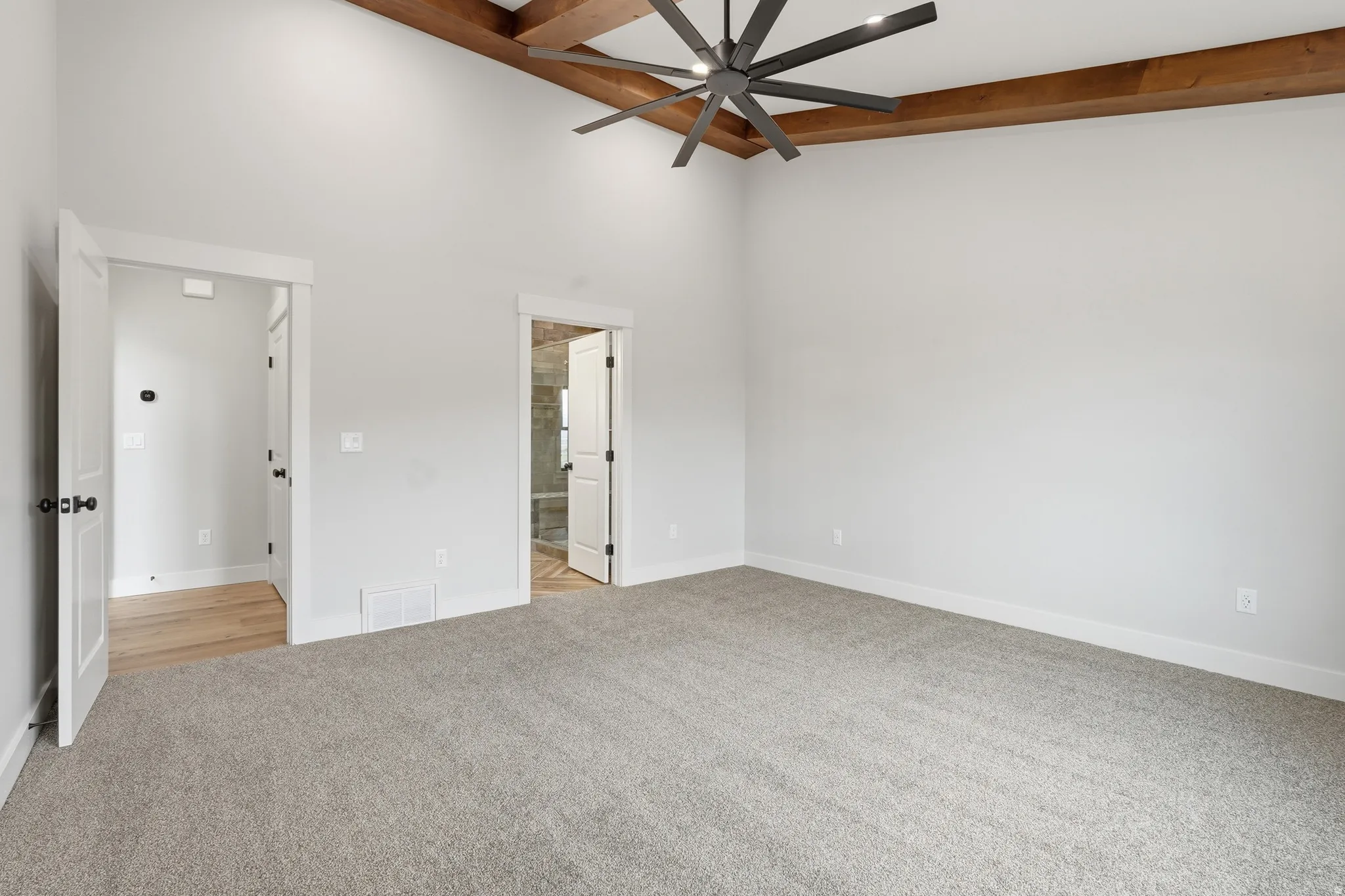 Unfurnished bedroom featuring light carpet and a ceiling fan