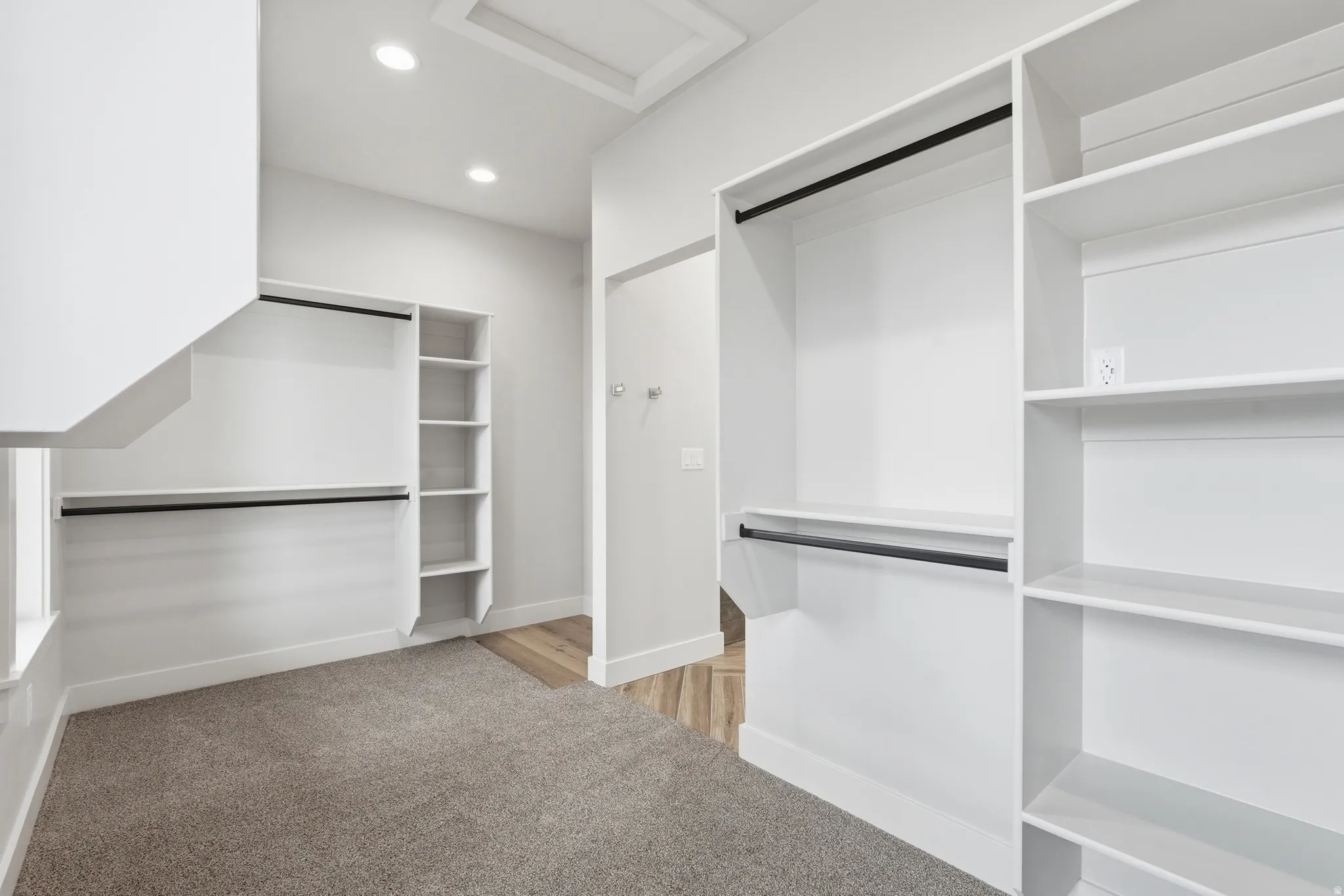 Walk in closet with attic access and light colored carpet