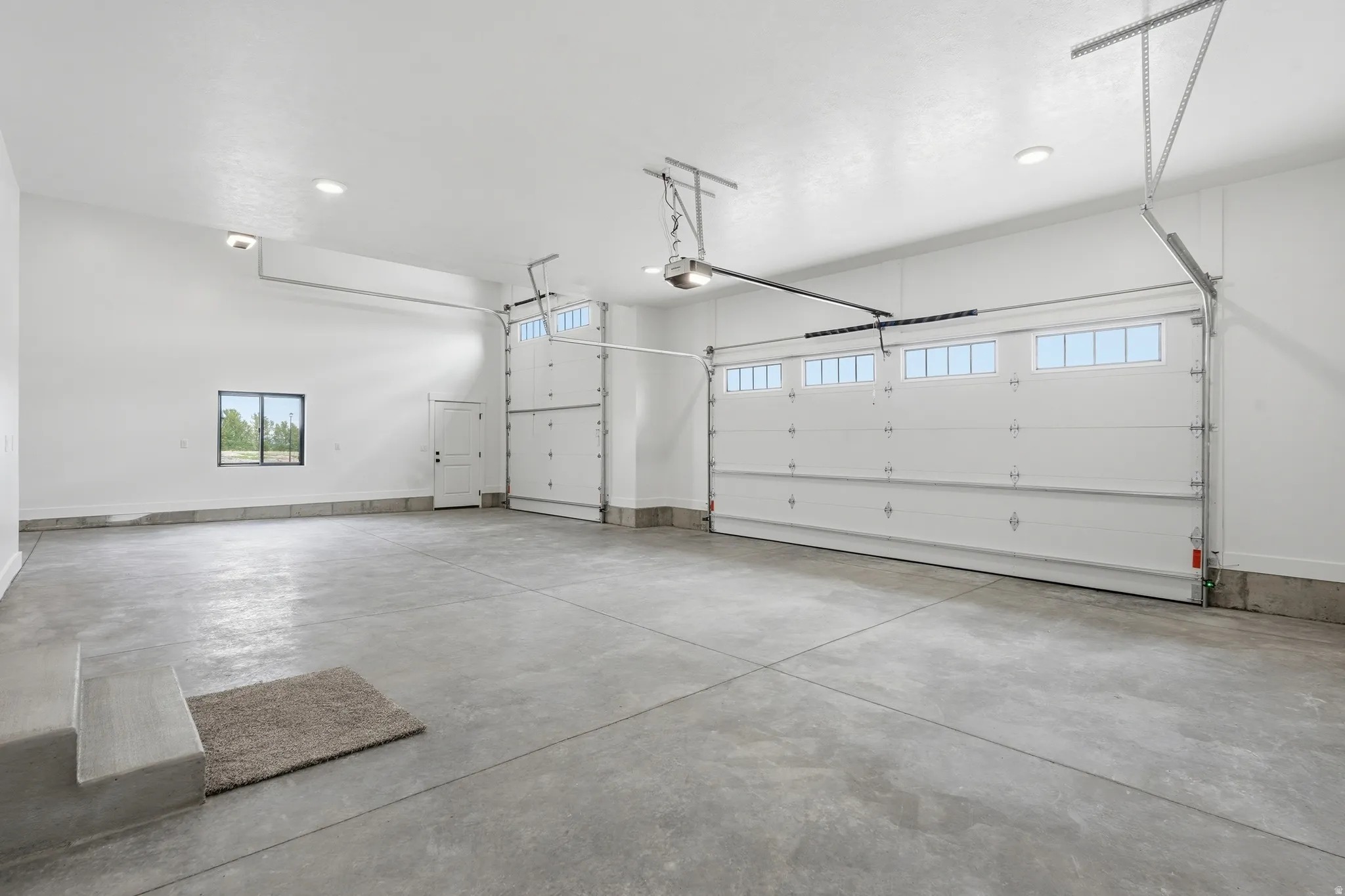 Garage featuring a garage door opener and recessed lighting