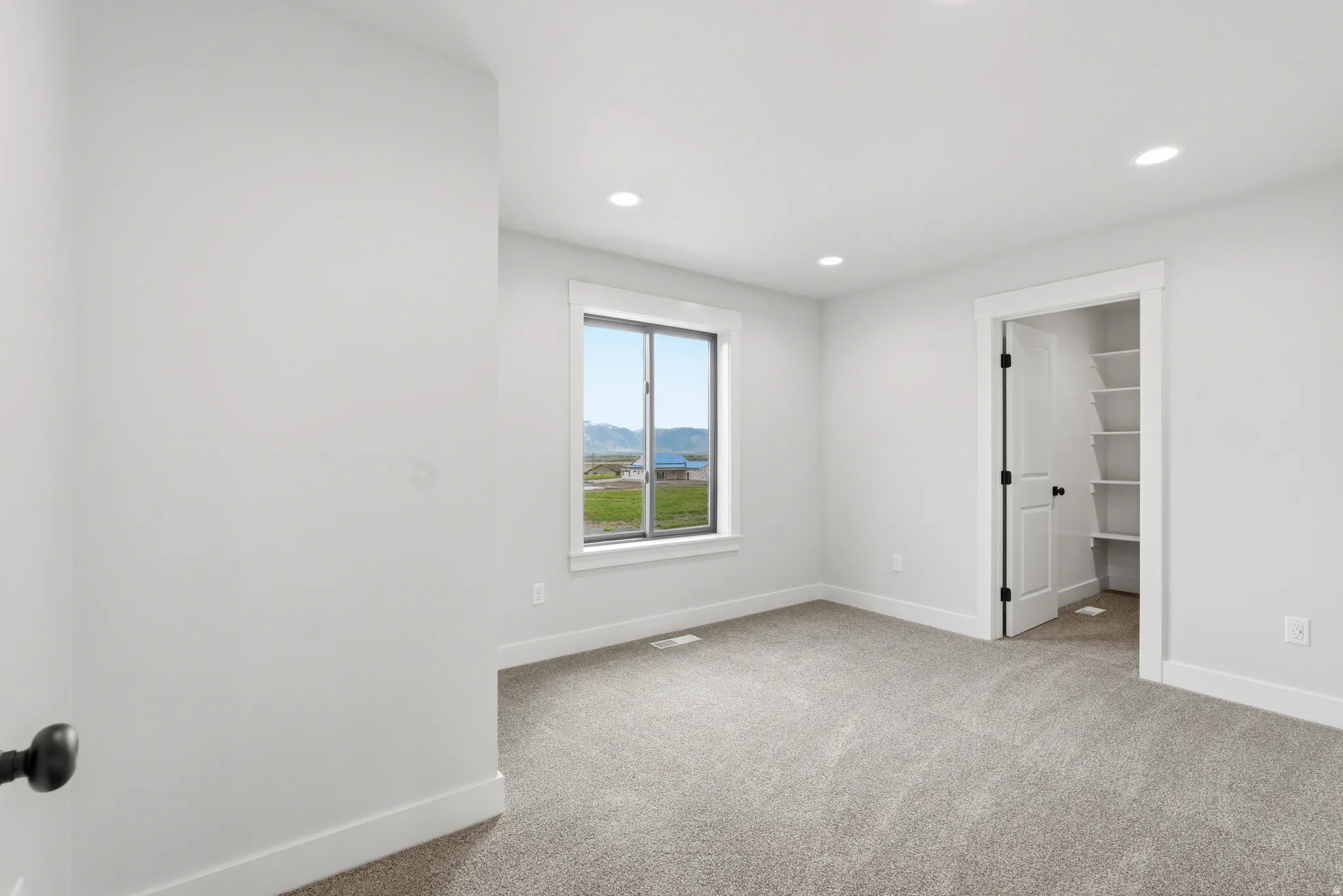 Unfurnished bedroom with a spacious closet, light carpet, and recessed lighting