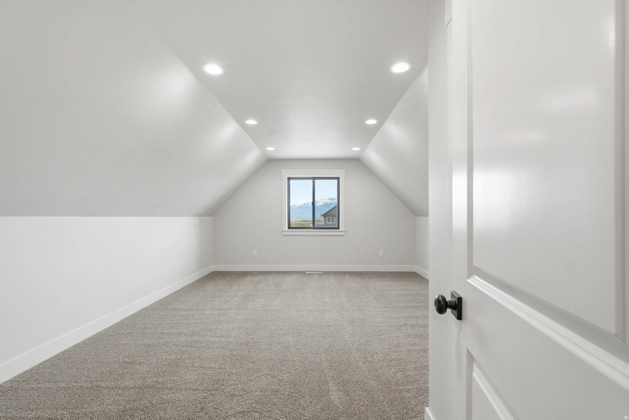 Additional living space with recessed lighting and light carpet