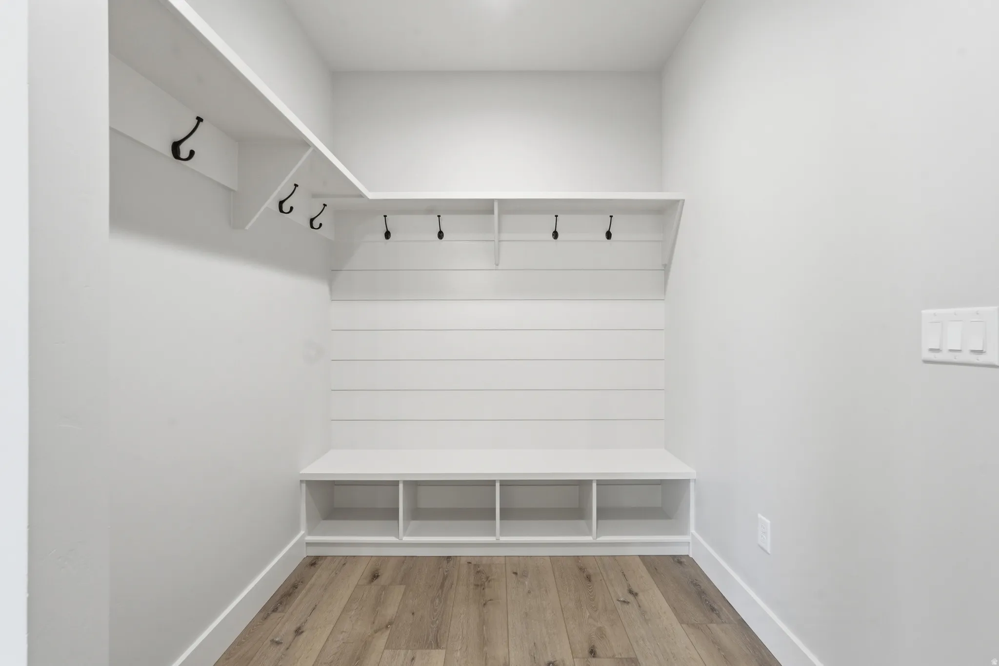 Mudroom with light wood-type flooring and baseboards