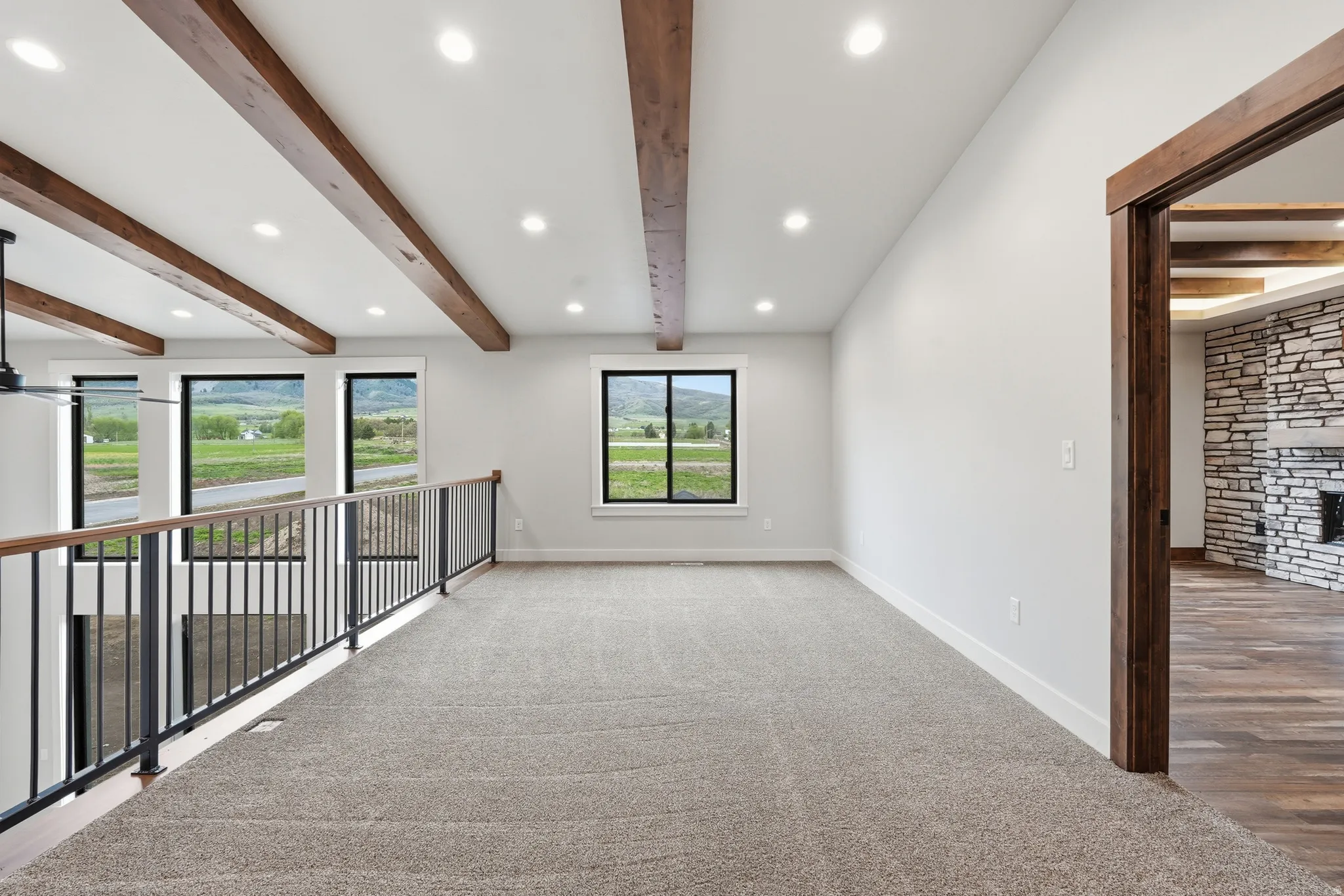 Carpeted spare room with beamed ceiling, recessed lighting, and a fireplace