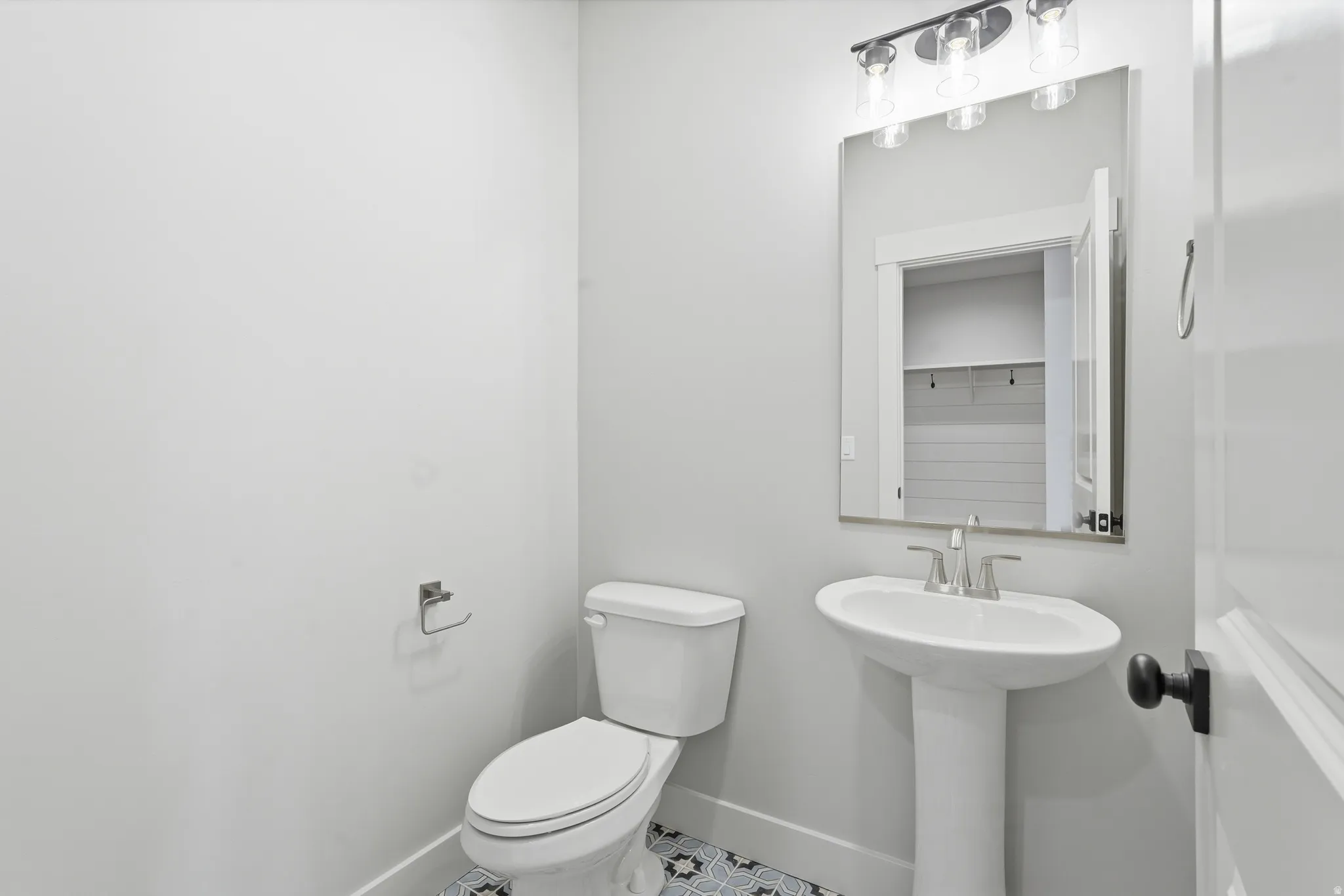 Half bath with toilet and tile patterned flooring