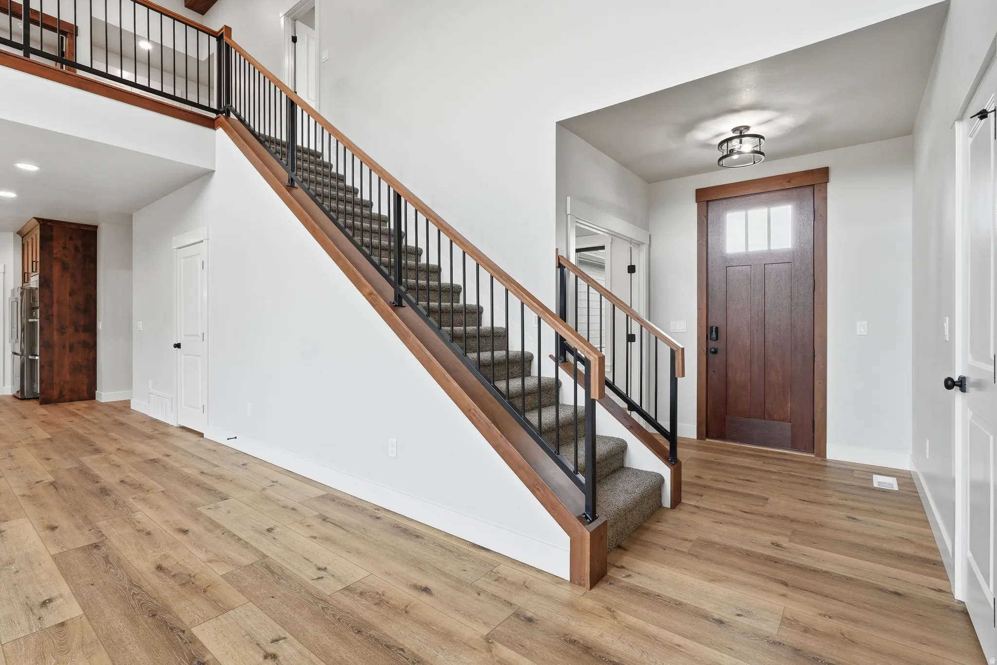 Entrance foyer with light wood finished floors, a high ceiling, and recessed lighting