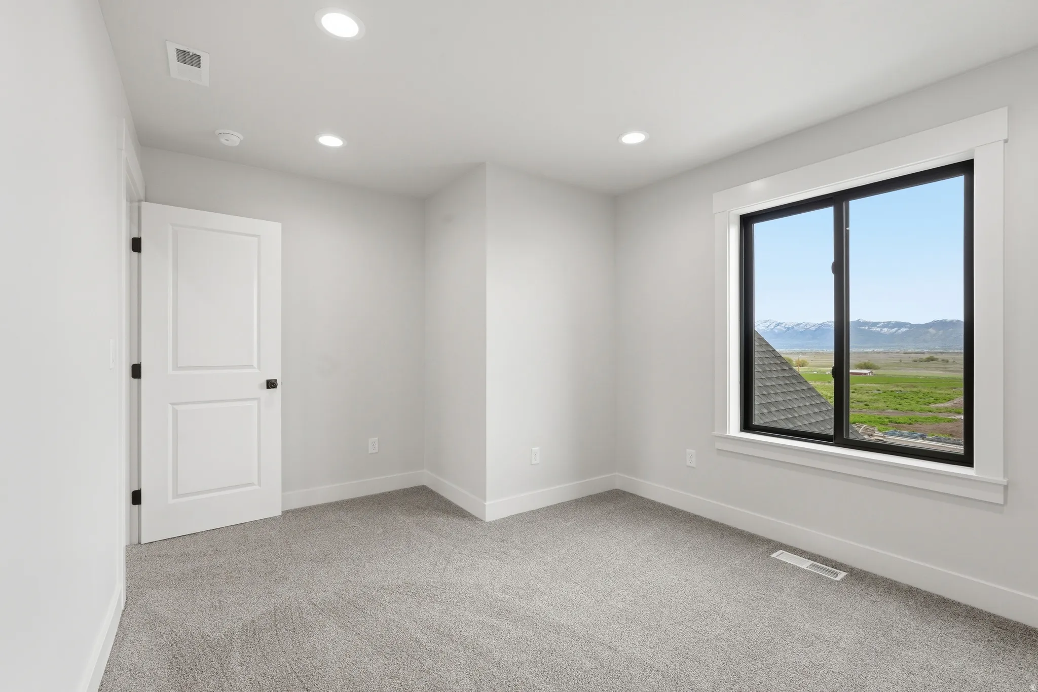 Spare room with a mountain view, light colored carpet, and recessed lighting