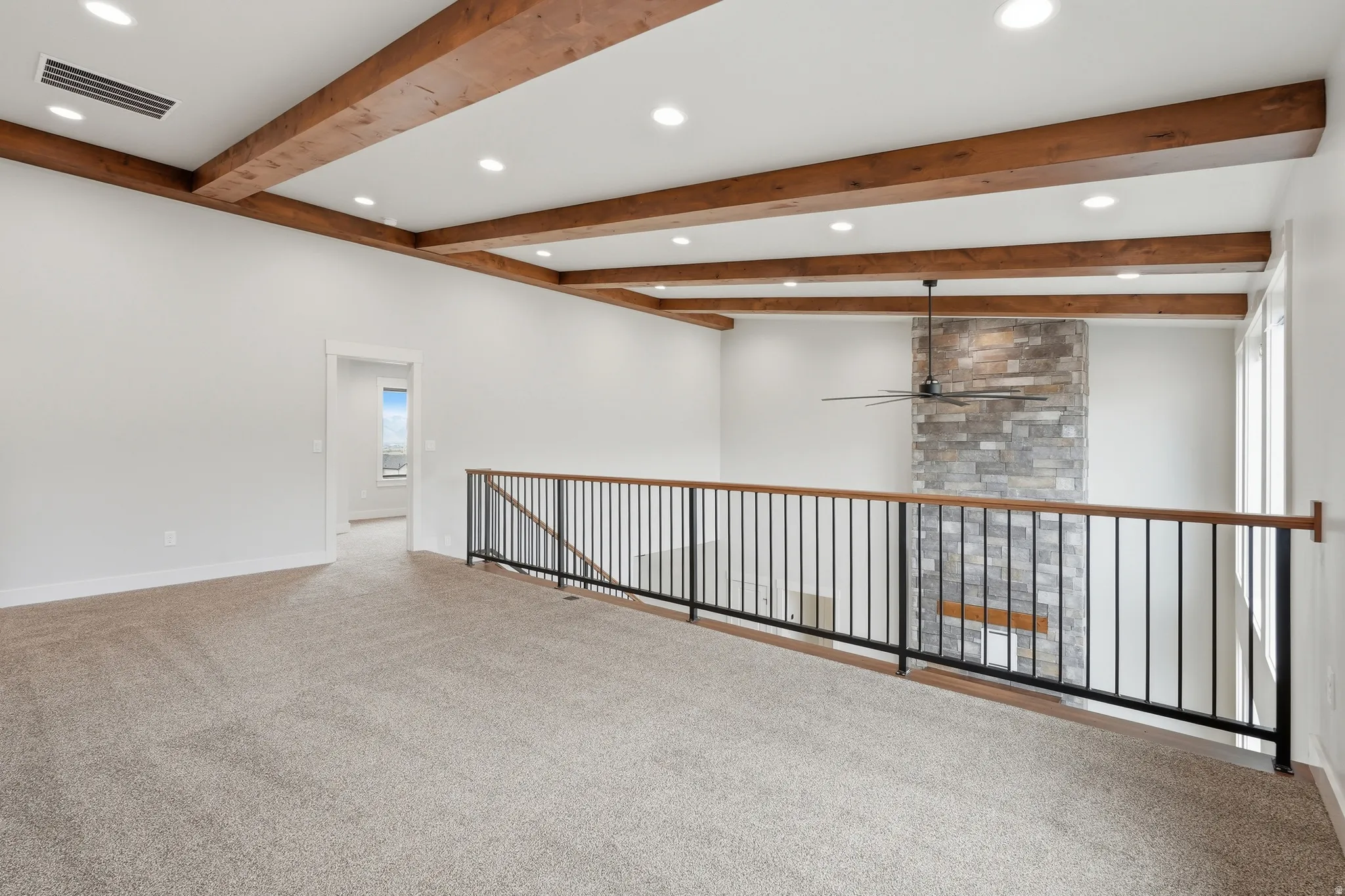 Carpeted empty room with beam ceiling, ceiling fan, and recessed lighting