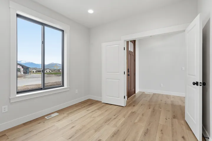 Spare room featuring light wood-type flooring, a mountain view, and recessed lighting