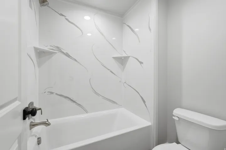 Full bath featuring toilet and bathtub / shower combination