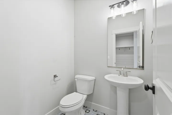 Half bath with toilet and tile patterned flooring