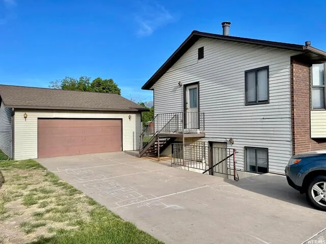 View of front of home with an outdoor structure and a garage