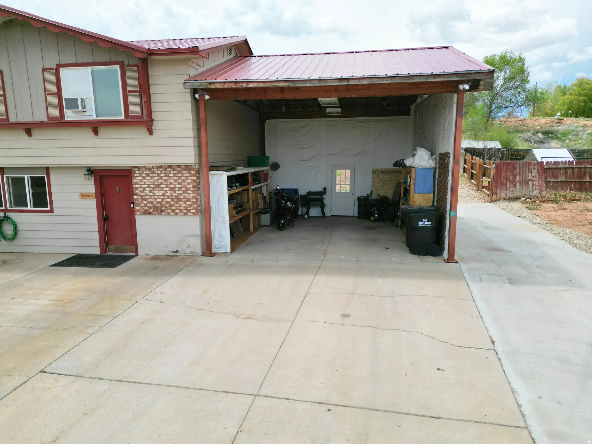 View of front of home featuring a metal roof, concrete driveway, and board and batten siding