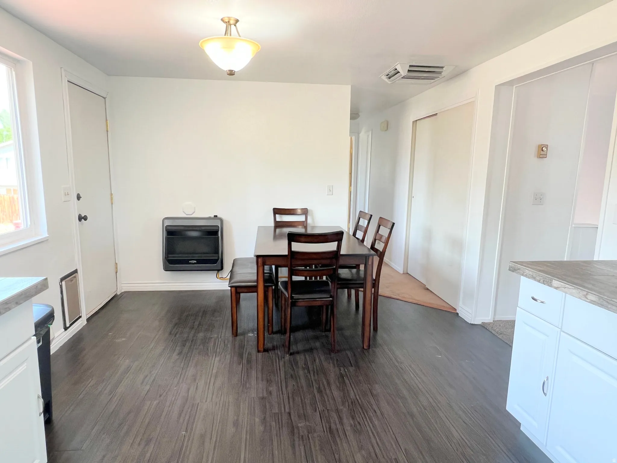 Dining space featuring dark wood-style floors and heating unit