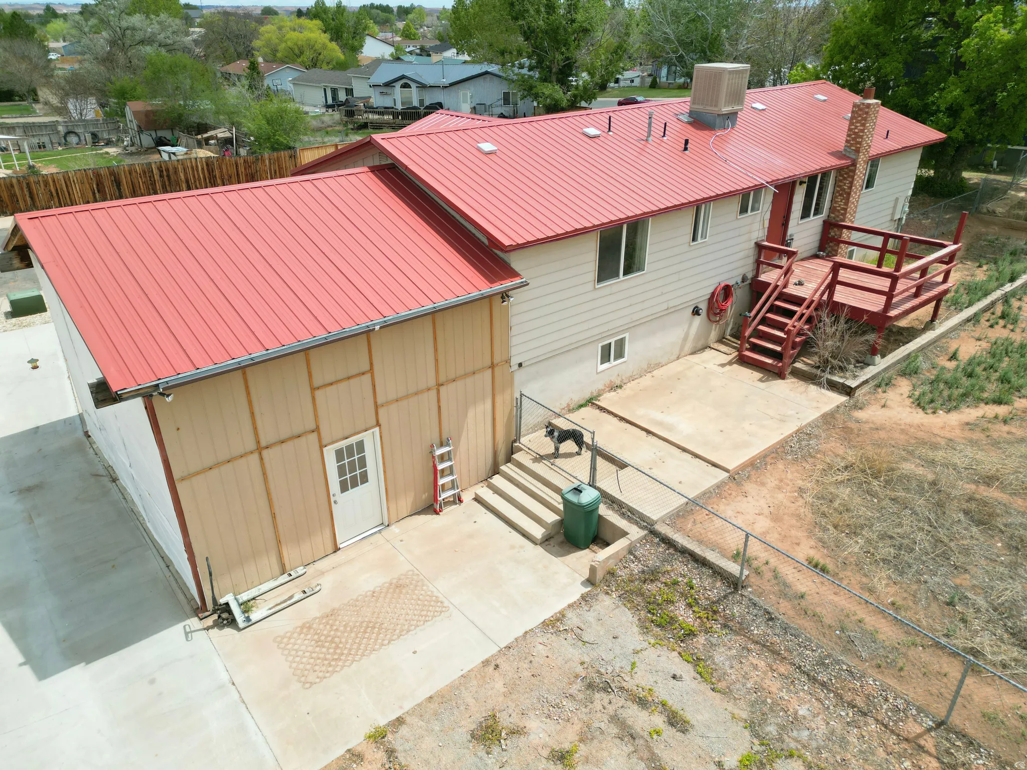 Back of property with a metal roof, a deck, and a patio area