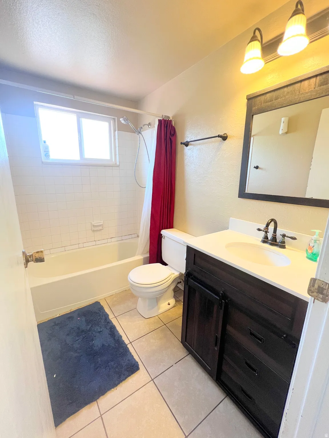 Full bath with vanity, shower / bath combo, and light tile patterned floors