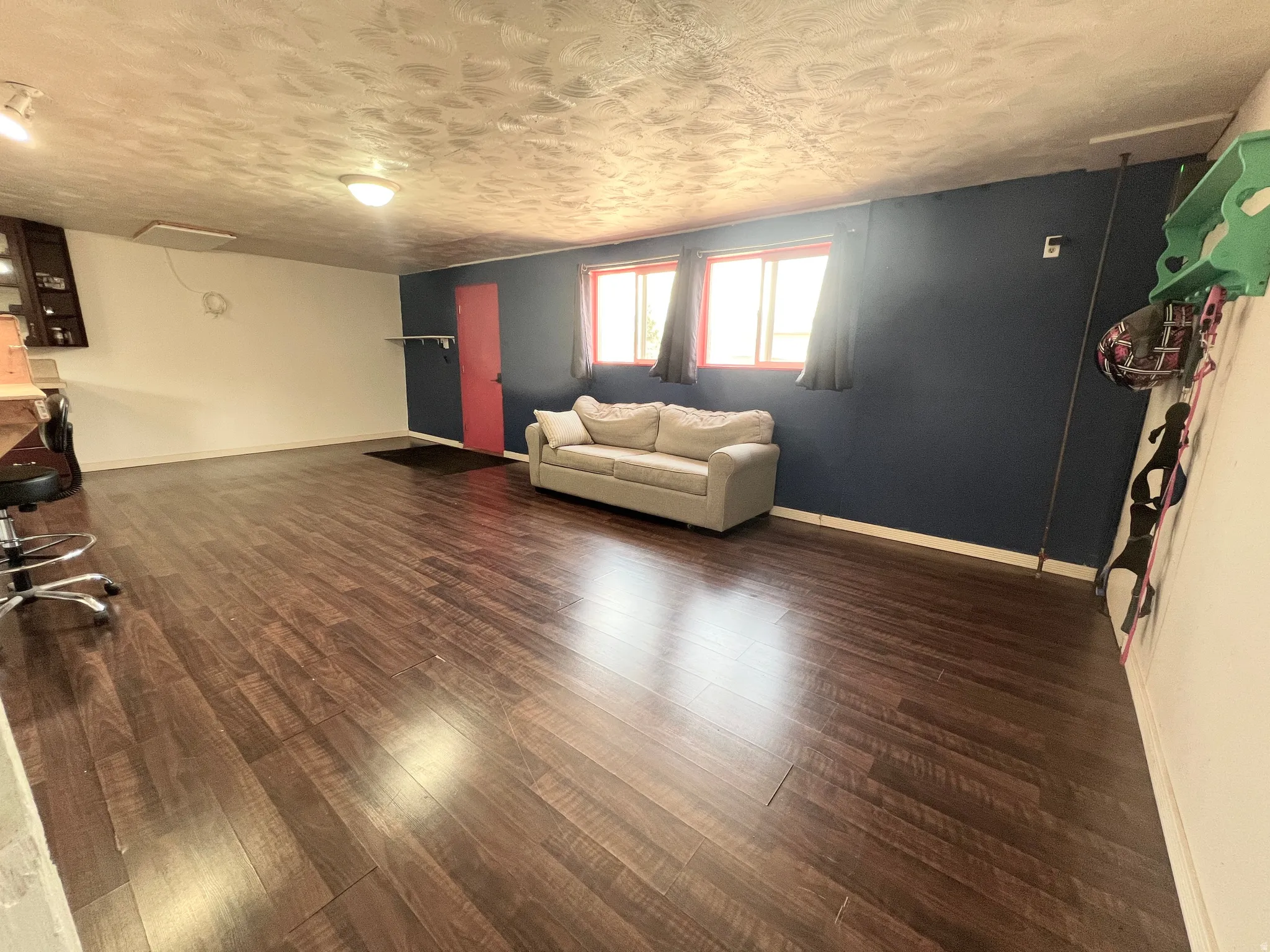 Living area featuring dark wood-style flooring and baseboards