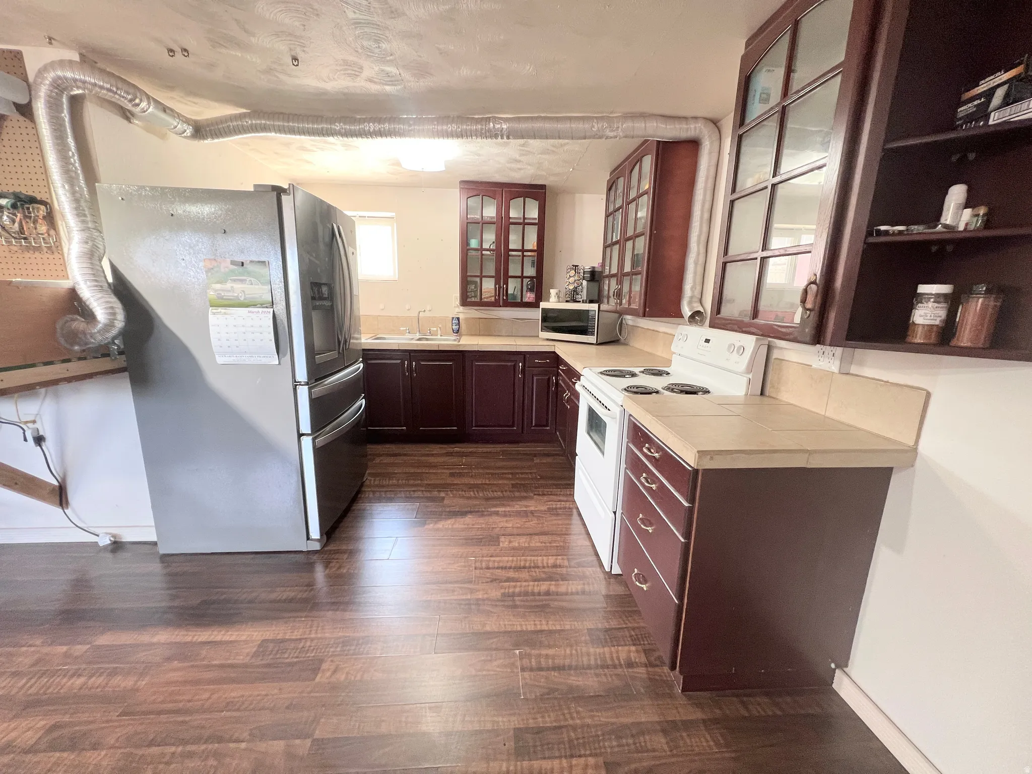 2nd Kitchen featuring stainless steel appliances, tile countertops, glass insert cabinets, and dark wood finished floors