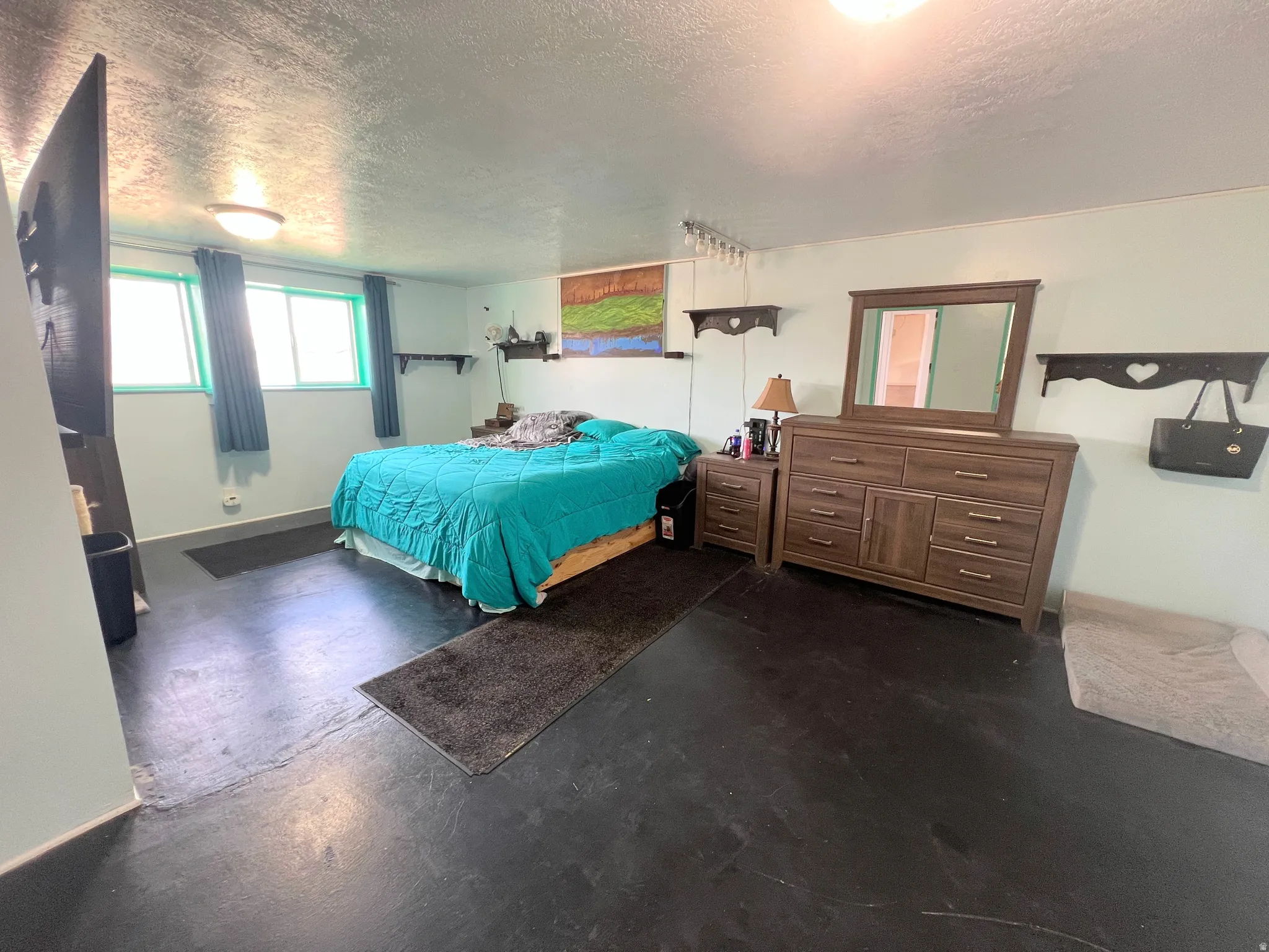 Bedroom featuring finished concrete floors and a textured ceiling