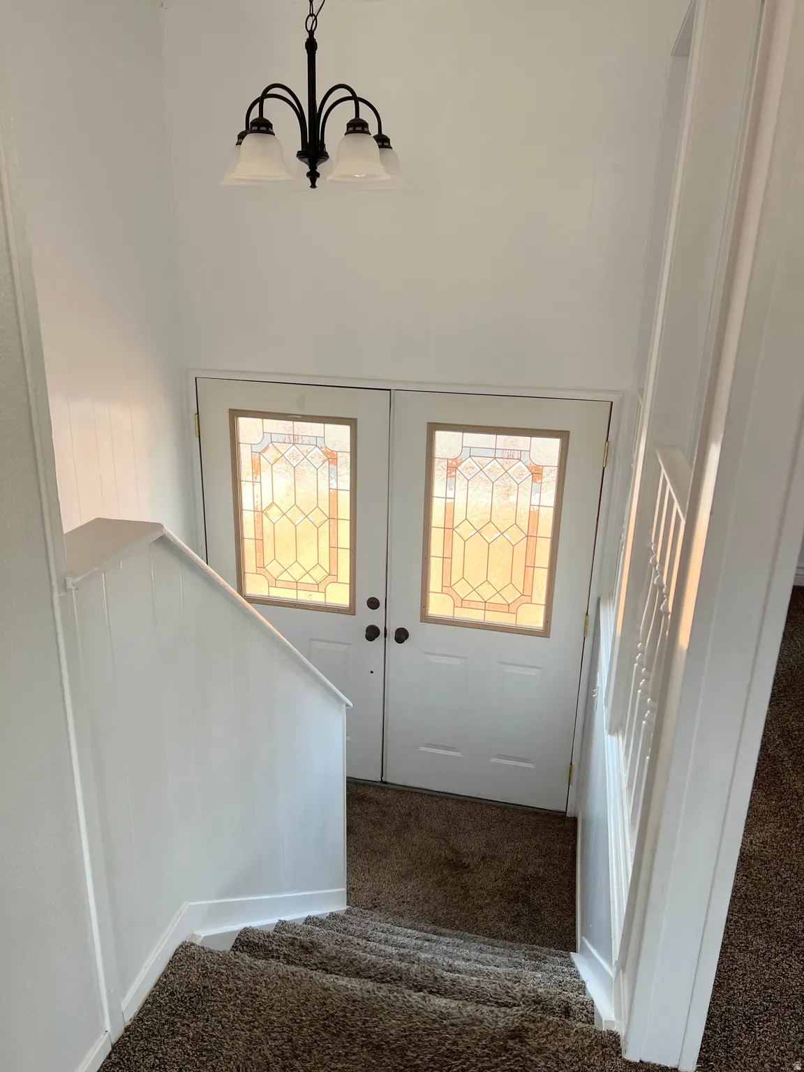 Foyer featuring dark carpet and suspended lighting
