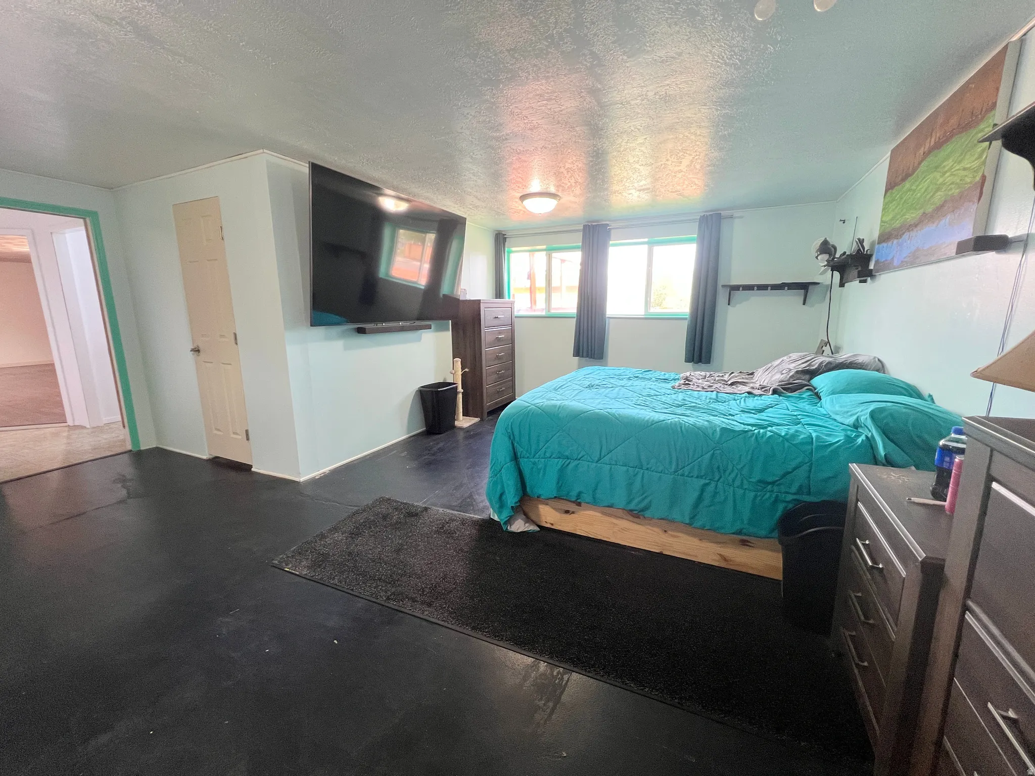 Bedroom featuring a textured ceiling and finished concrete floors