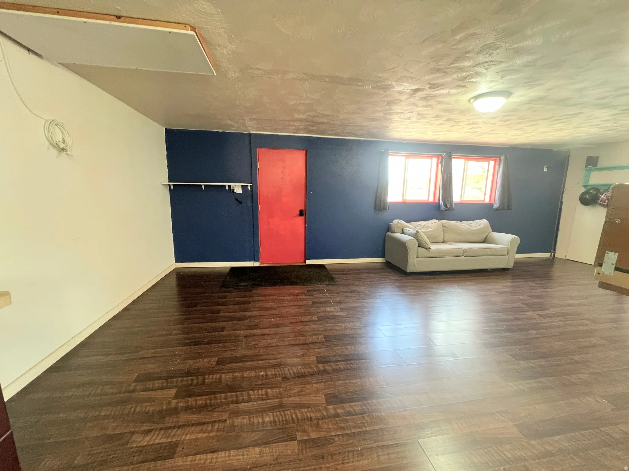 Living area with dark wood-style flooring and baseboards