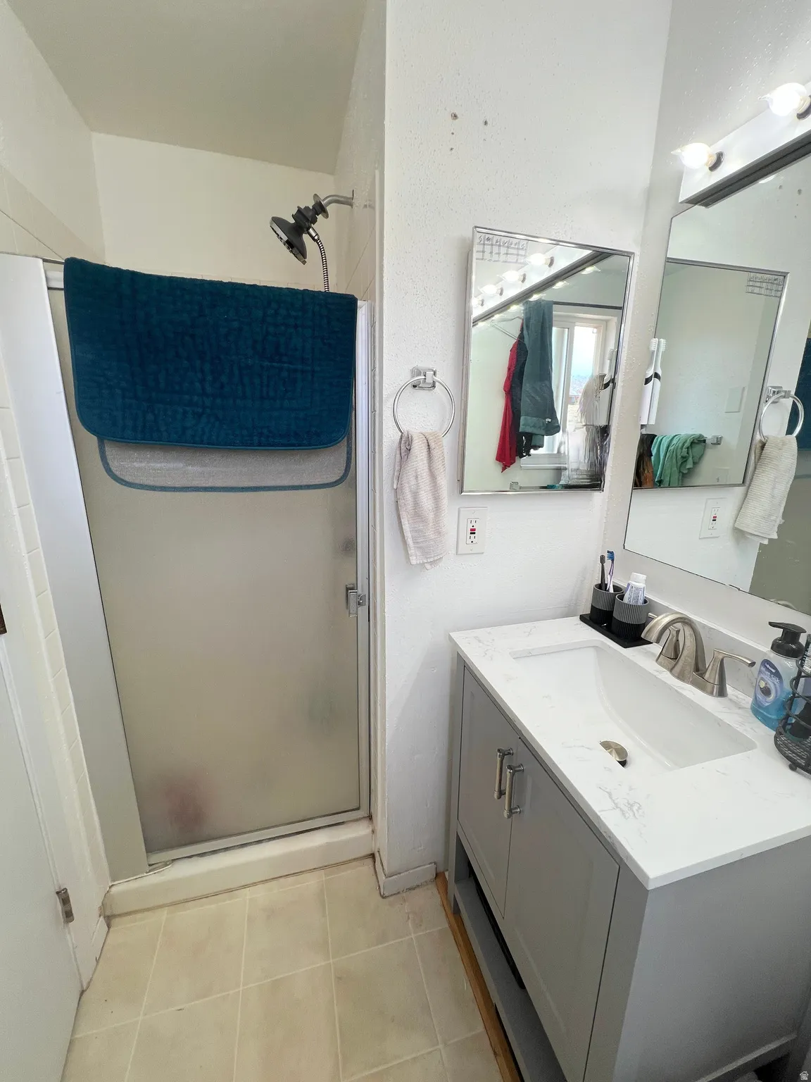 Bathroom with a stall shower, vanity, and light tile patterned floors