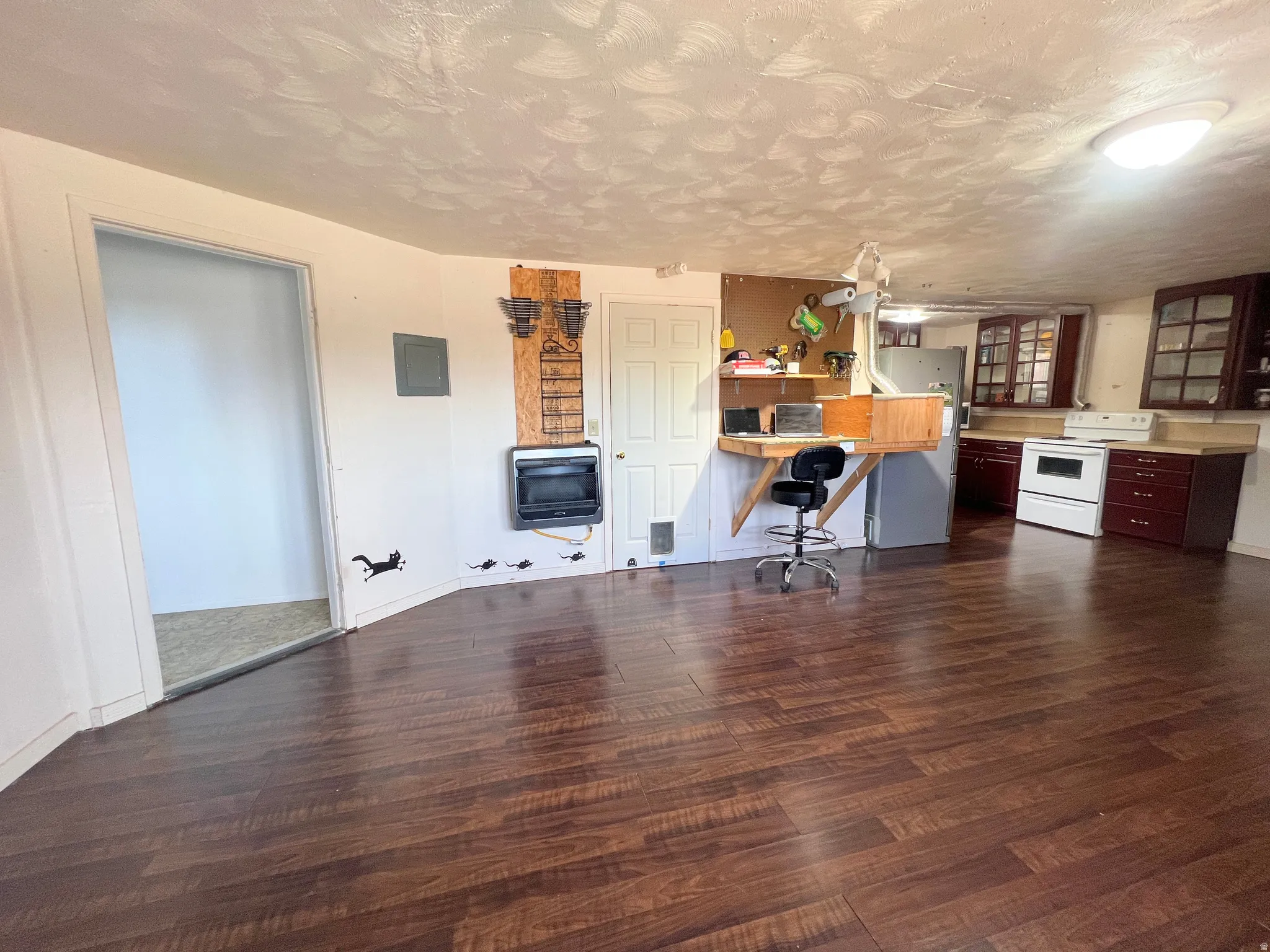 2nd Kitchen with dark wood-type flooring, light countertops, freestanding refrigerator, white electric stove, and electric panel