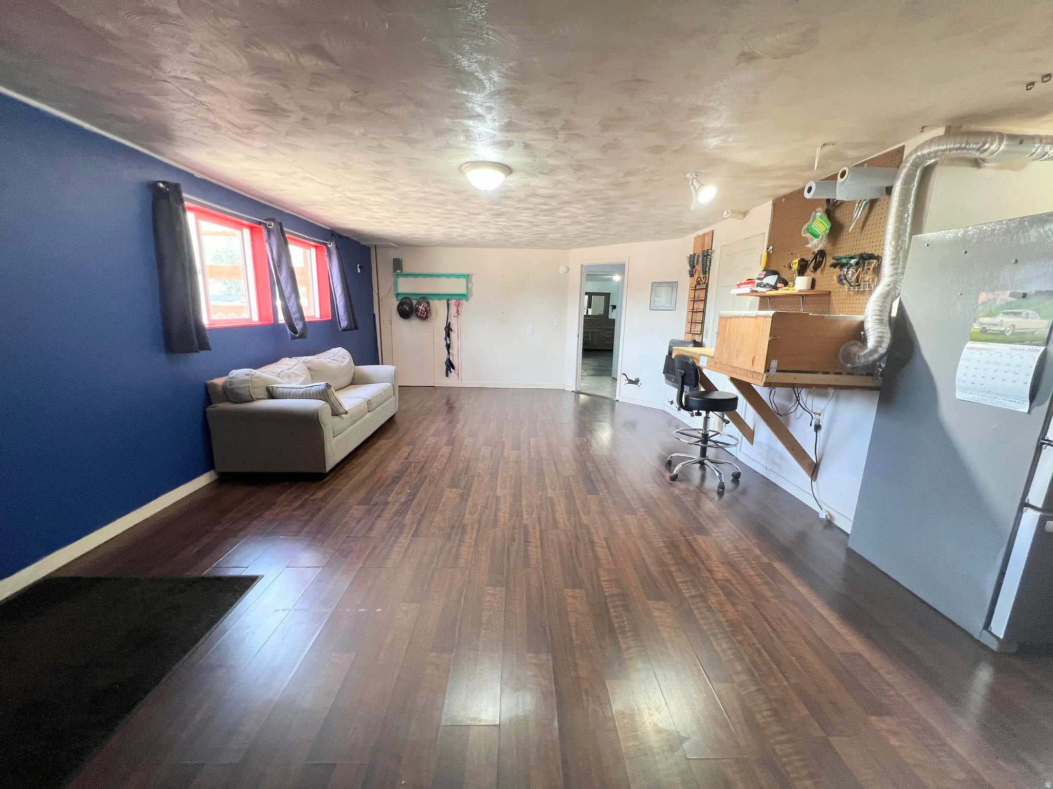 Office with dark wood-style floors and a textured ceiling