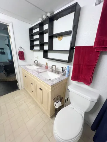 Ensuite bathroom with double vanity and a textured wall