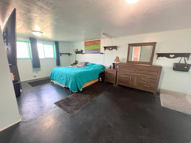 Bedroom featuring finished concrete floors and a textured ceiling