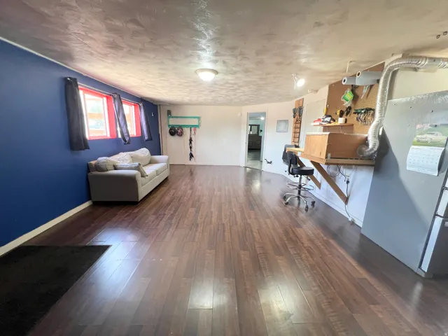 Office with dark wood-style floors and a textured ceiling