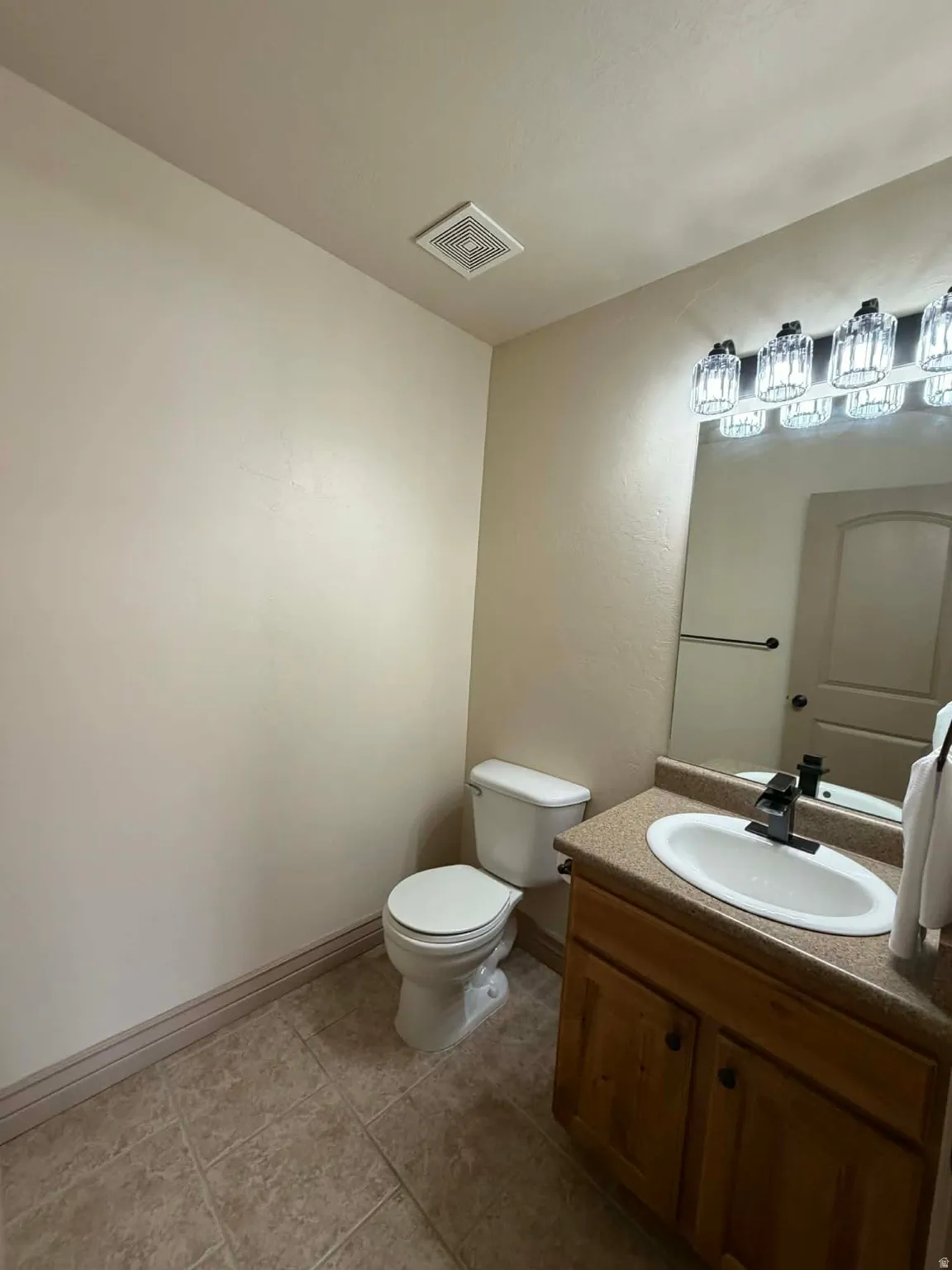Half bathroom with vanity and light tile patterned flooring
