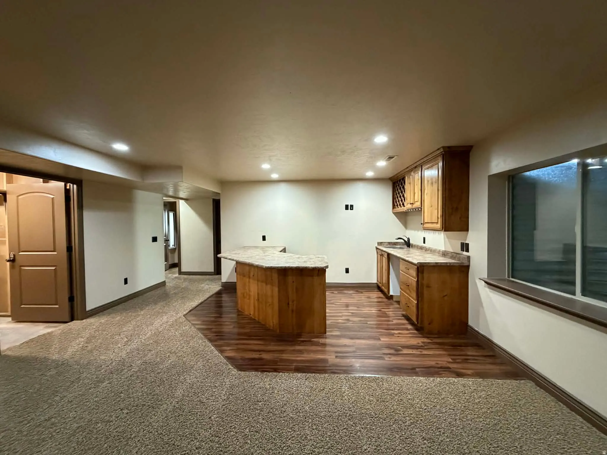 Bar featuring wood finish cabinetry, dark carpet, recessed lighting, dark wood-style flooring, and light stone counters
